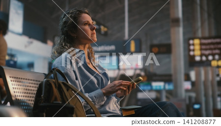 Female Traveler Scanning Digital Ticket on Smartphone While Drinking Coffee Female Traveler Scanning Digital Ticket on Smartphone While Drinking Coffee 141208877