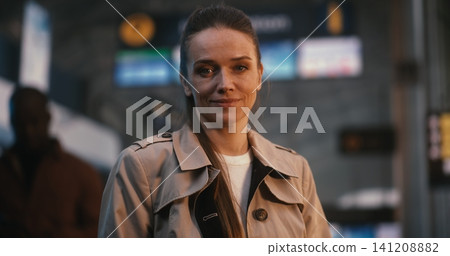 Confident Young Female Passenger Standing in Terminal with Smile Confident Young Female Passenger Standing in Terminal with Smile 141208882