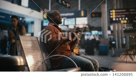 Adult Man with Suitcase Arriving at Gate and Checking Digital Ticket Adult Man with Suitcase Arriving at Gate and Checking Digital Ticket 141208895