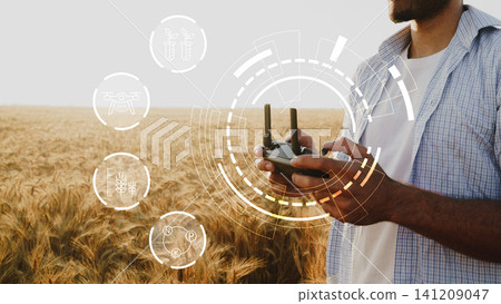Smart farm technology in action with a drone controller and wheat field at sunset Smart farm technology in action with a drone controller and wheat field at sunset 141209047