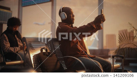 Focused Adult Man Taking Selfie with Smartphone in Airport Terminal Focused Adult Man Taking Selfie with Smartphone in Airport Terminal 141209106