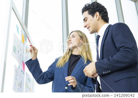 Man and woman businesspeople planning business strategy and shaking hands in office. Business, education and office concept. Man and woman businesspeople planning business strategy and shaking hands in office. Business, education and office concept. 141209142