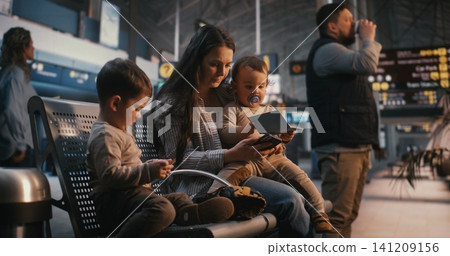 Mother with Two Toddlers Waiting in Airport Terminal Hall Before Flight Mother with Two Toddlers Waiting in Airport Terminal Hall Before Flight 141209156