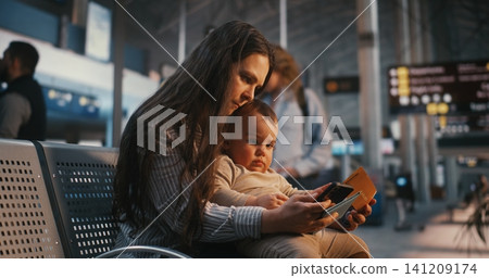 Family Travelers Using Mobile Device and Checking Boarding Pass at Departure Lounge Family Travelers Using Mobile Device and Checking Boarding Pass at Departure Lounge 141209174