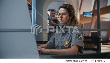 Airport Safety Personnel Analyzing Xray Images at Departure Checkpoint 141209178