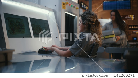 Airport Security Checkpoint with Travelers Retrieving Bags and Guard Monitoring Screens Airport Security Checkpoint with Travelers Retrieving Bags and Guard Monitoring Screens 141209271