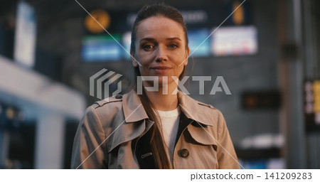 Confident Young Female Passenger Standing in Terminal with Smile Confident Young Female Passenger Standing in Terminal with Smile 141209283