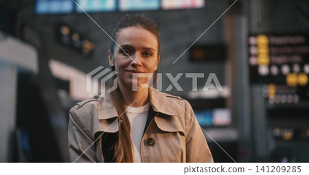 Beautiful Woman Smiling in Crowded Airport Terminal with Motion Blur Passengers Beautiful Woman Smiling in Crowded Airport Terminal with Motion Blur Passengers 141209285