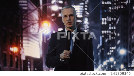 Serious Middle Aged News Correspondent Reporting Live from Urban Location during Nighttime 141209345