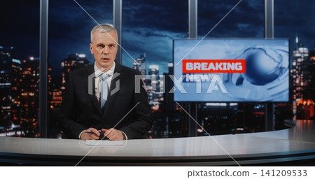 Mature Professional News Correspondent Presenting Information at Desk in Modern Newsroom Studio Mature Professional News Correspondent Presenting Information at Desk in Modern Newsroom Studio 141209533