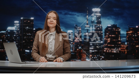 Professional Female Broadcaster Sits at Studio Desk Delivering Analytical News Segment Professional Female Broadcaster Sits at Studio Desk Delivering Analytical News Segment 141209673