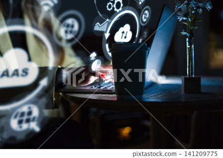 Working with software as a service in a dim room at nighttime Working with software as a service in a dim room at nighttime 141209775