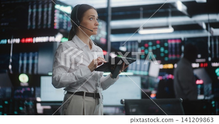 Professional Female Stock Exchange Trader on Trading Floor With Tablet Professional Female Stock Exchange Trader on Trading Floor With Tablet 141209863