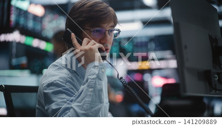 Professional Broker Taking Urgent Call on Landline Phone at Trading Desk Professional Broker Taking Urgent Call on Landline Phone at Trading Desk 141209889