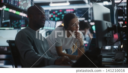 Female Financial Supervisor Mentoring Male Analyst at Stock Exchange Station 141210016