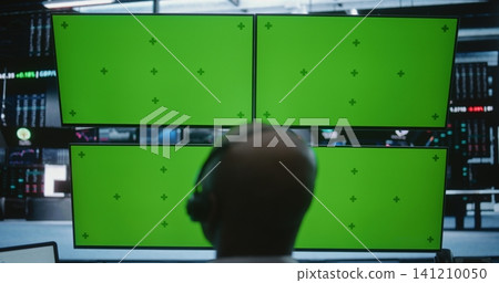 Male Trader Working Modern High Tech Desk With Four Green Screen Monitors in Busy Financial Office Male Trader Working Modern High Tech Desk With Four Green Screen Monitors in Busy Financial Office 141210050