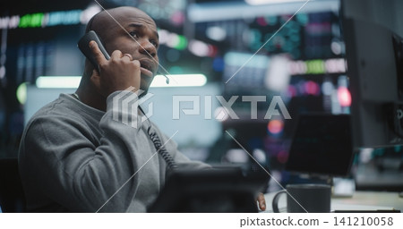Professional Broker Closely Monitoring Charts and Calling Landline Phone Receiver Professional Broker Closely Monitoring Charts and Calling Landline Phone Receiver 141210058