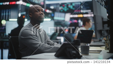 Male Stock Broker Analyzing Complex Trading Data at Multi Monitor Desk Male Stock Broker Analyzing Complex Trading Data at Multi Monitor Desk 141210134
