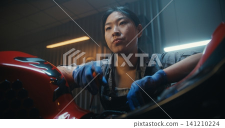 Female Mechanic Beside Partially Disassembled Motorcycle, Tired and Discouraged 141210224