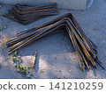 Bundles of rusty-brown, L shaped steel rebar are neatly stacked on concrete pad. Prevent bars are an essential construction material, ready for use in reinforcing structures at the construction site. 141210259