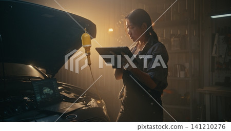 In Advanced Repair Setting, Female Integrates Laptop Diagnostics and AI Powered Tablet Analysis In Advanced Repair Setting, Female Integrates Laptop Diagnostics and AI Powered Tablet Analysis 141210276