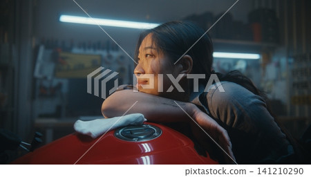 Tired But Happy Female Biker Resting Her Head on Motorcycle Tank After Repair and Polishing Tired But Happy Female Biker Resting Her Head on Motorcycle Tank After Repair and Polishing 141210290