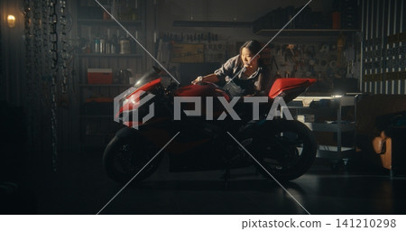 Sun Streams Into Stylish Garage as Biker Woman Tenderly Polishes Motorcycle Sun Streams Into Stylish Garage as Biker Woman Tenderly Polishes Motorcycle 141210298