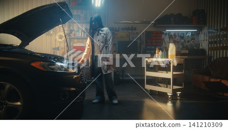 Young Female in Stylish Everyday Clothes, Having Just Arrived at Private, Well Equipped Garage Young Female in Stylish Everyday Clothes, Having Just Arrived at Private, Well Equipped Garage 141210309