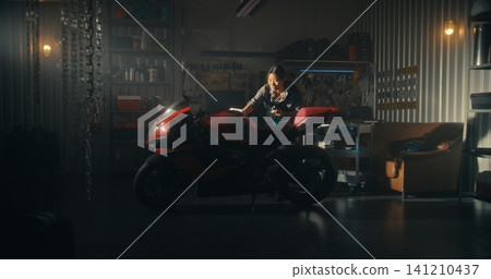 Woman Lovingly Clean Motorcycle in Modern Garage Filled With Golden Light Woman Lovingly Clean Motorcycle in Modern Garage Filled With Golden Light 141210437