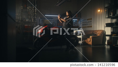 In Garage Setting, Woman Rider Briefly Stops Routine to Captures Sunset In Garage Setting, Woman Rider Briefly Stops Routine to Captures Sunset 141210596