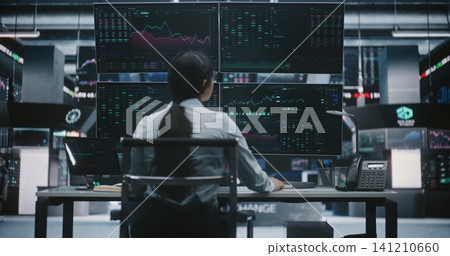 Woman Trader Leans Over Digital Tablet Verify Financial Data While Sitting in Front Large Monitors. Woman Trader Leans Over Digital Tablet Verify Financial Data While Sitting in Front Large Monitors. 141210660