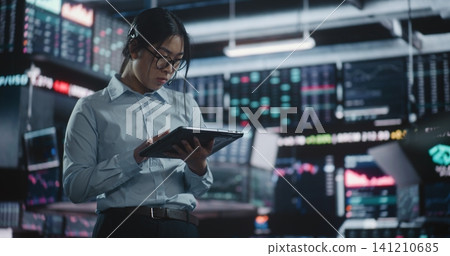 Professional Woman Stands Before Quad Monitor Setup, Holding Tablet Monitor Real Time Stock Indices Professional Woman Stands Before Quad Monitor Setup, Holding Tablet Monitor Real Time Stock Indices 141210685