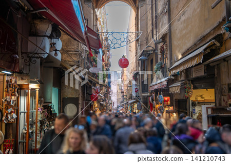 Naples, italy. December 28, 2024. People walking along san gregorio armeno street in naples, italy, a historic alley known for its christmas nativity workshops and festive atmosphere 141210743