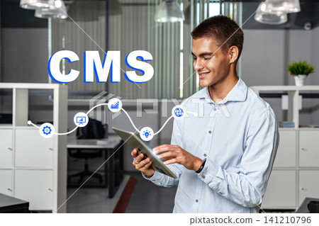 Man working with a tablet in an office environment focused on content management systems 141210796