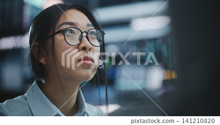 Stock Exchange Female Trader Makes Well Considered Calculated Investment Decisions in Equities Stock Exchange Female Trader Makes Well Considered Calculated Investment Decisions in Equities 141210820