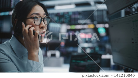 Anxious Female Trader Talking on Smartphone During Stock Market Crash in Digital Office Anxious Female Trader Talking on Smartphone During Stock Market Crash in Digital Office 141210840