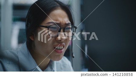 Female Trader Receives Call Via Headset While Monitoring Financial Data Female Trader Receives Call Via Headset While Monitoring Financial Data 141210858
