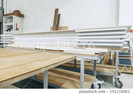 Furniture workshop shows stacked wood boards and work tables used for crafting furniture Furniture workshop shows stacked wood boards and work tables used for crafting furniture 141210861