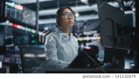 Female Trader Analyzing Real Time Stock Market Data at Large Screens Female Trader Analyzing Real Time Stock Market Data at Large Screens 141210874