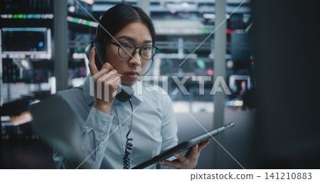 Stock Exchange Trader Compares Analytical Data on Tablet With Large Financial Charts Stock Exchange Trader Compares Analytical Data on Tablet With Large Financial Charts 141210883