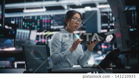 Stylish Stock Broker Consulting on Headset, Using Tablet Digital Workstation Stylish Stock Broker Consulting on Headset, Using Tablet Digital Workstation 141210935
