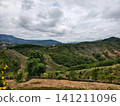 A beautiful panoramic view from a viewpoint overlooking lush green mountain ranges and hills under an overcast cloudy sky. Perfect for nature background and travel tourism concepts. 141211096