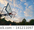 A low angle view of an outdoor basketball hoop under a dramatic evening sky with golden clouds. Perfect for sports, inspiration, motivation, and healthy lifestyle concepts. 141211097