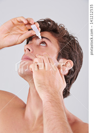 Man, allergies and treatment with eye drops for sight, vision or care on a gray studio background. Male person or young model with pharmaceutical for optic hygiene, dry pupil or iris on mockup space Man, allergies and treatment with eye drops for sight, vision or care on a gray studio background. Male person or young model with pharmaceutical for optic hygiene, dry pupil or iris on mockup space 141212535