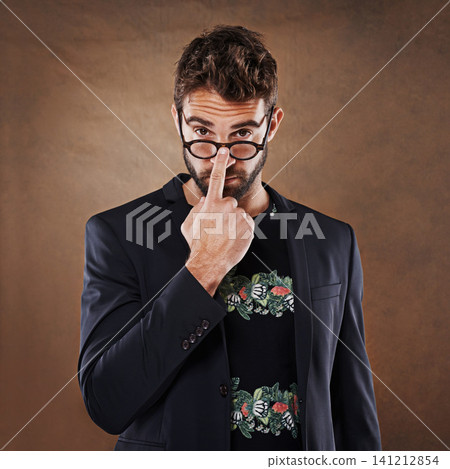 Glasses, fashion and portrait of man in studio with blazer for classy, stylish and trendy outfit with confidence. Spectacles, serious and male person with elegant and fancy style by brown background. Glasses, fashion and portrait of man in studio with blazer for classy, stylish and trendy outfit with confidence. Spectacles, serious and male person with elegant and fancy style by brown background. 141212854