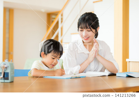 A first-grader doing homework in the living room. A first-grader doing homework in the living room. 141213266