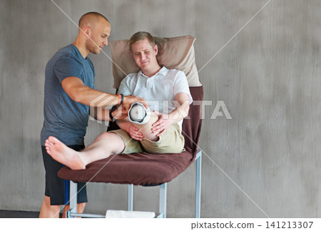 Therapist, man with disability or prothesis in healthy, recovery or teamwork in physical wellbeing. Person, physio or leg on bed as healthcare, support or assessment of medical fitting in exam mockup Therapist, man with disability or prothesis in healthy, recovery or teamwork in physical wellbeing. Person, physio or leg on bed as healthcare, support or assessment of medical fitting in exam mockup 141213307