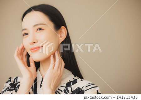 一位身穿浴衣的女子正在護膚。 一位身穿浴衣的女子正在護膚。 141213433