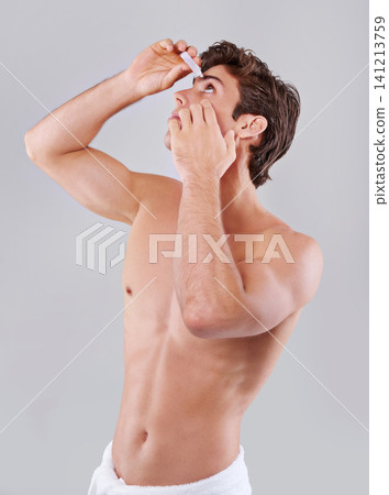 Man, allergies and hygiene with eye drops for sight, vision or care on a gray studio background. Male person or young model with pharmaceutical in optical treatment, dry pupil or iris on mockup space Man, allergies and hygiene with eye drops for sight, vision or care on a gray studio background. Male person or young model with pharmaceutical in optical treatment, dry pupil or iris on mockup space 141213759