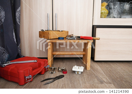 Tools and materials are arranged on a work surface for a home repair task in a workshop setting Tools and materials are arranged on a work surface for a home repair task in a workshop setting 141214390